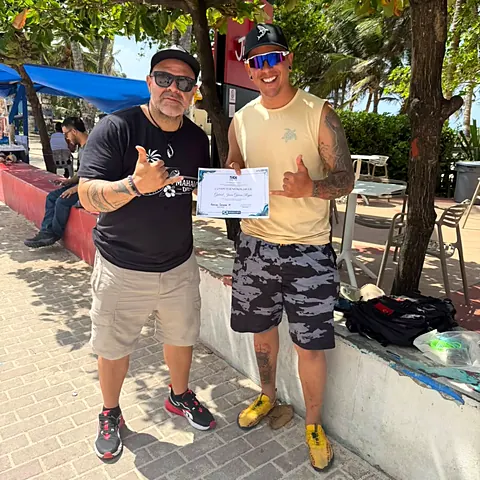 Instructor y buzo recién certificado en Nitrox posan con el certificado en San Andrés